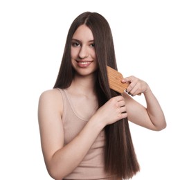 Photo of Smiling teenage girl brushing her shiny hair on white background