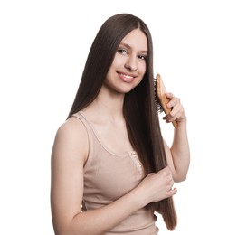 Photo of Smiling teenage girl brushing her shiny hair on white background