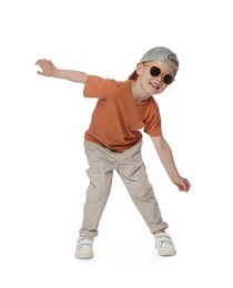 Photo of Happy little boy with sunglasses dancing on white background