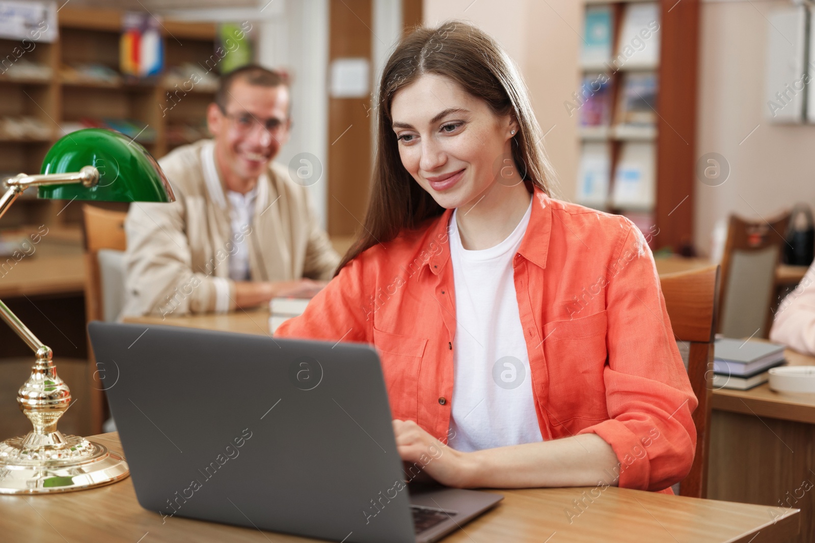 People studying at desks in public library, selective focus Photo of People studying at desks in public library, selective focus