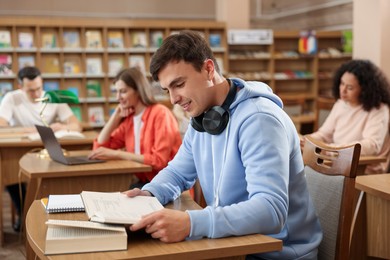 Photo of People studying at desks in public library, selective focus