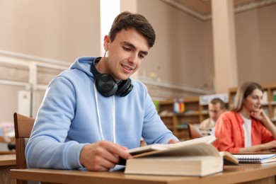Photo of People studying at desks in public library, selective focus