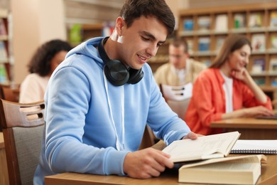 Photo of People studying at desks in public library, selective focus