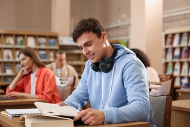 Photo of People studying at desks in public library, selective focus