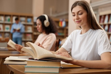 Photo of People studying at desks in public library, selective focus