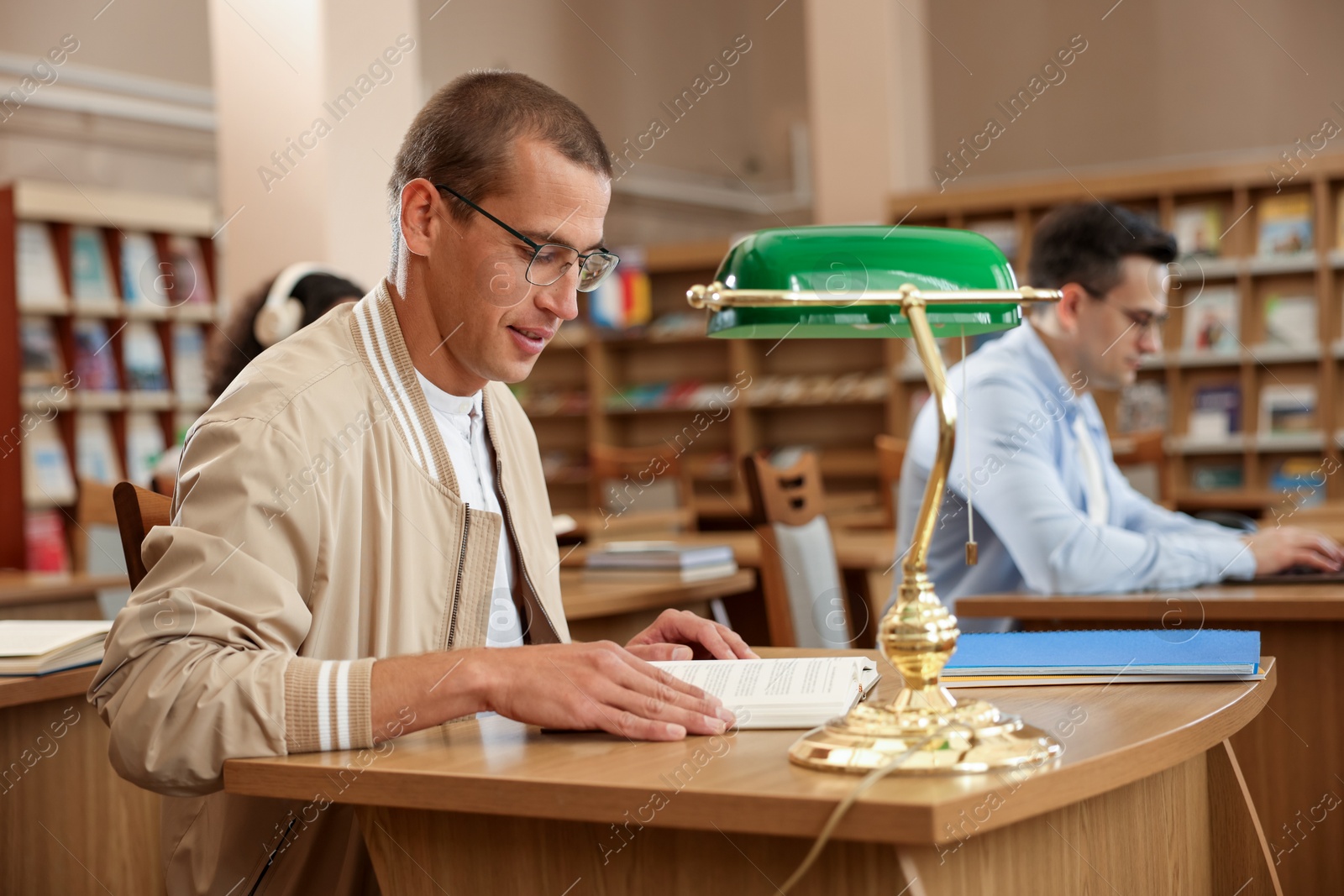 People studying at desks in public library, selective focus Photo of People studying at desks in public library, selective focus