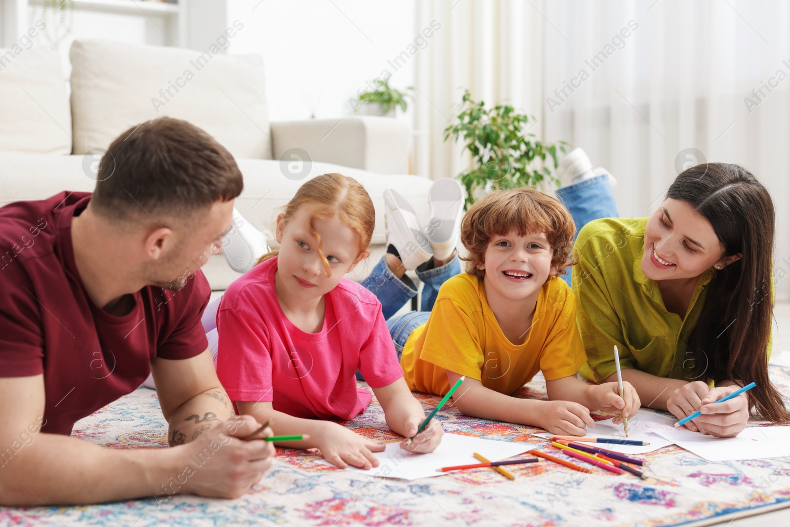 Photo of Parents teaching their kids to draw on floor at home