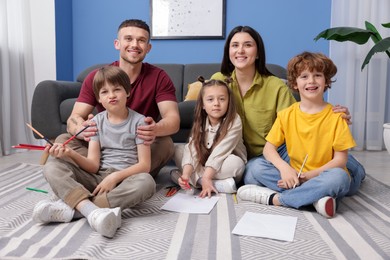 Photo of Parents teaching their kids to draw on floor at home