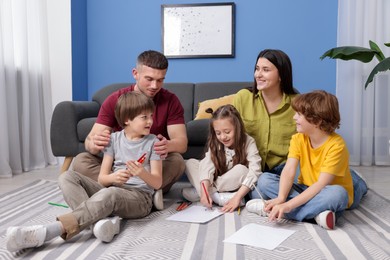Photo of Parents teaching their kids to draw on floor at home