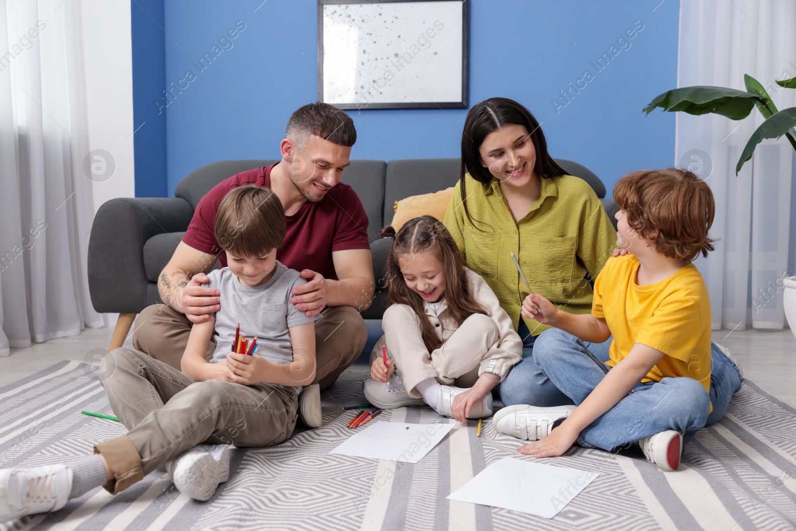 Parents teaching their kids to draw on floor at home Photo of Parents teaching their kids to draw on floor at home