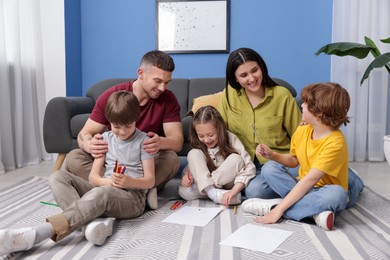 Photo of Parents teaching their kids to draw on floor at home