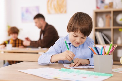 Photo of Kids with teacher at painting lesson indoors, selective focus. Learning to draw