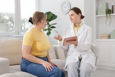 Photo of Weight loss. Nutritionist consulting overweight woman in clinic