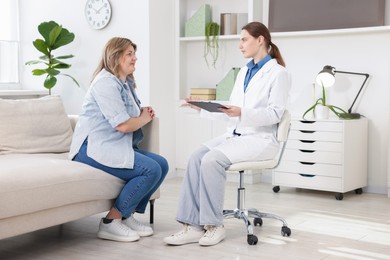 Photo of Weight loss. Nutritionist consulting overweight woman in clinic