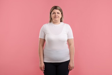 Photo of Weight loss. Plus size woman on pink background
