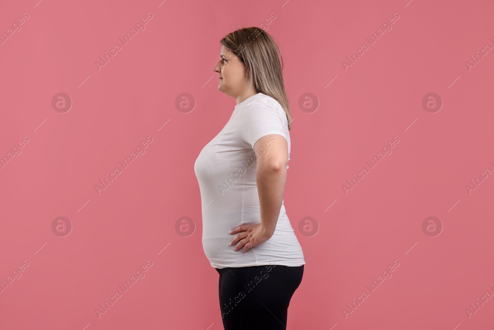 Weight loss. Plus size woman on pink background Photo of Weight loss. Plus size woman on pink background