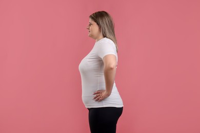 Photo of Weight loss. Plus size woman on pink background