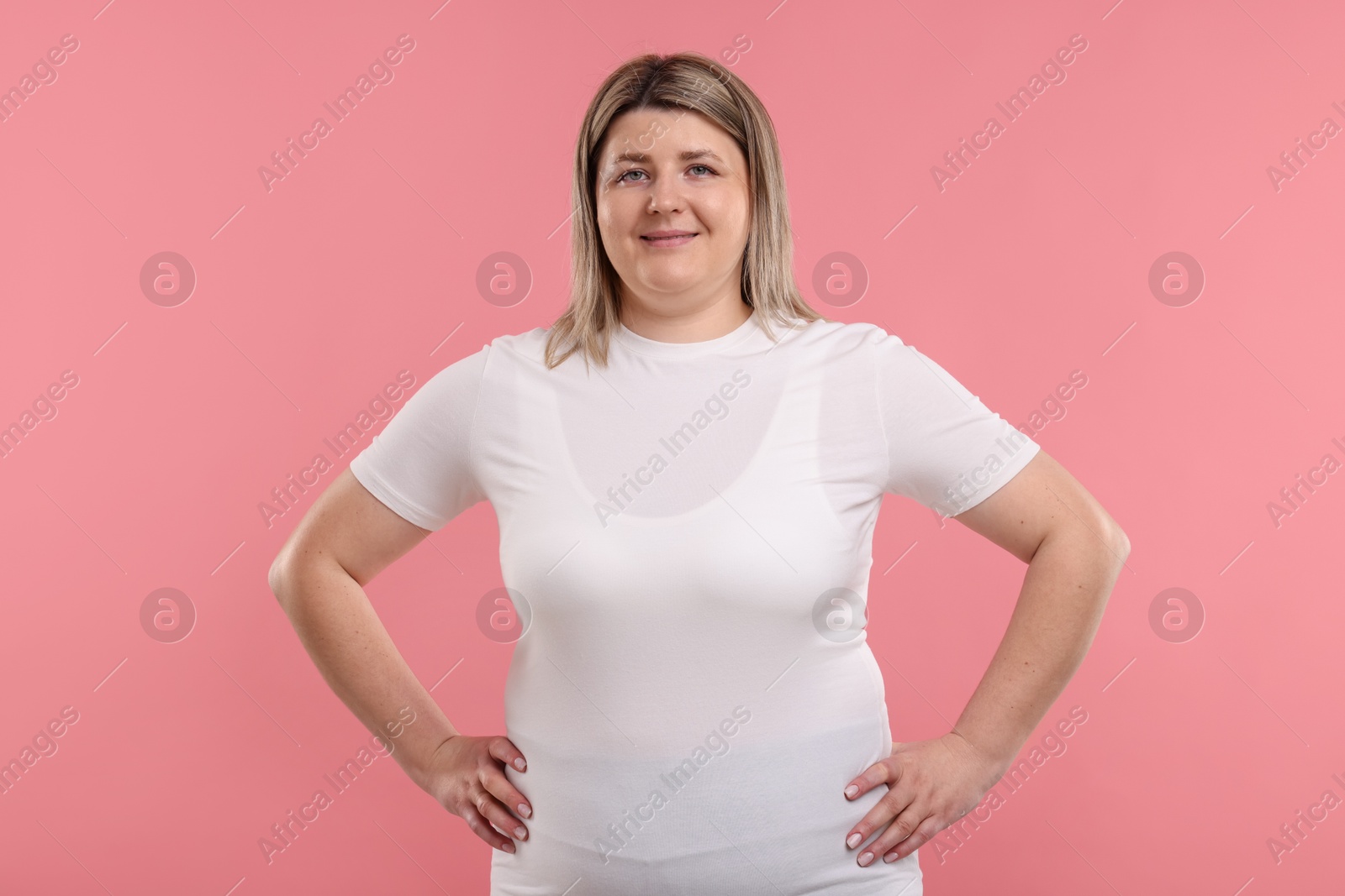 Photo of Weight loss. Plus size woman on pink background