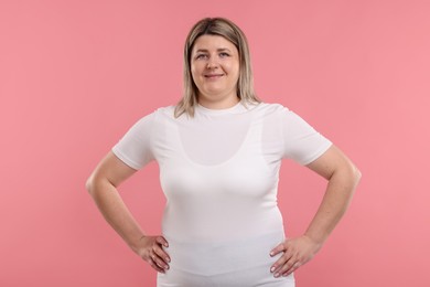 Photo of Weight loss. Plus size woman on pink background