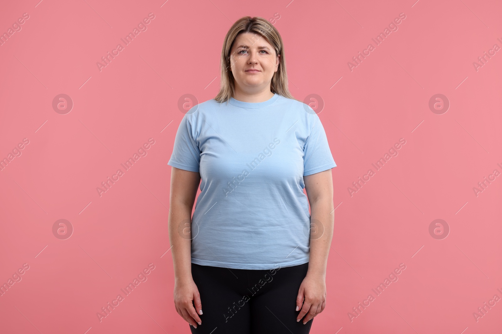 Weight loss. Plus size woman on pink background Photo of Weight loss. Plus size woman on pink background