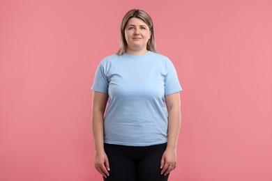 Photo of Weight loss. Plus size woman on pink background