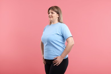 Photo of Weight loss. Plus size woman on pink background