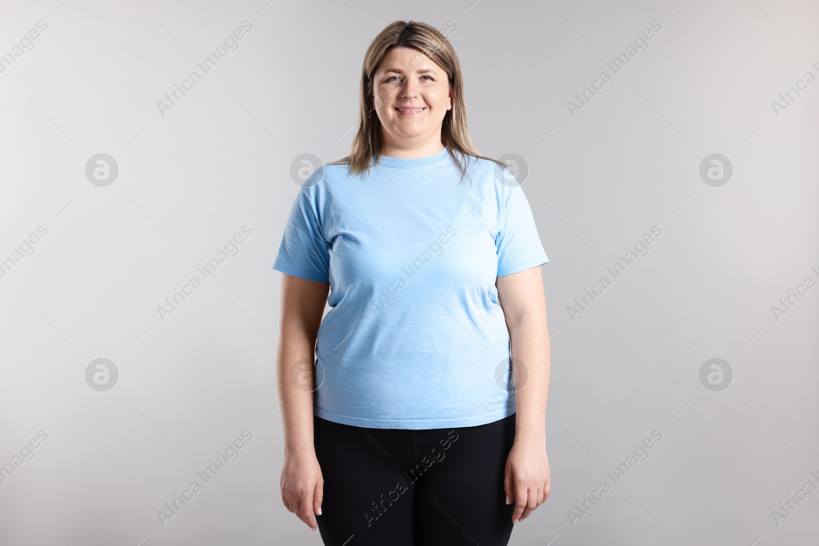 Weight loss. Plus size woman on gray background Photo of Weight loss. Plus size woman on gray background