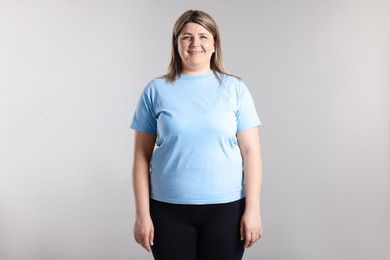 Photo of Weight loss. Plus size woman on gray background