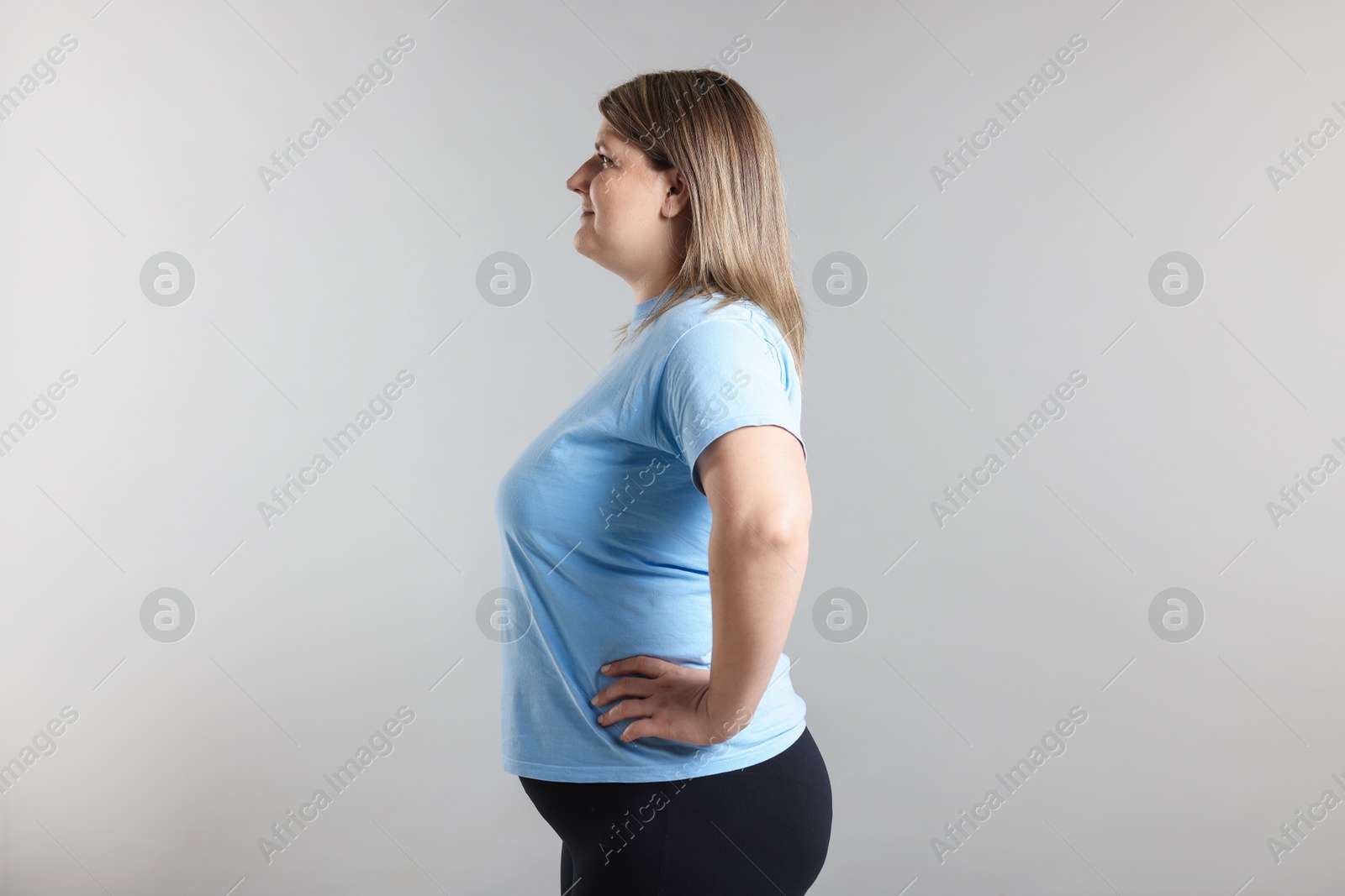 Weight loss. Plus size woman on gray background Photo of Weight loss. Plus size woman on gray background