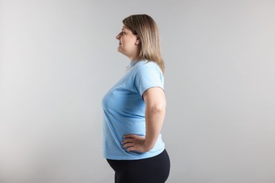Photo of Weight loss. Plus size woman on gray background