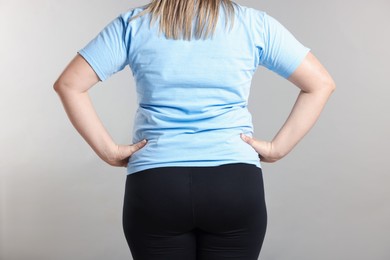Photo of Weight loss. Plus size woman on gray background, closeup