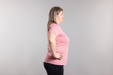 Photo of Weight loss. Plus size woman on gray background
