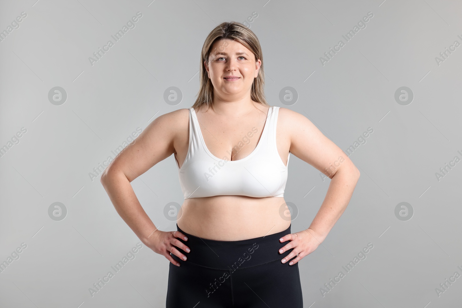 Photo of Weight loss. Plus size woman on gray background