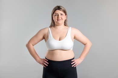 Photo of Weight loss. Plus size woman on gray background