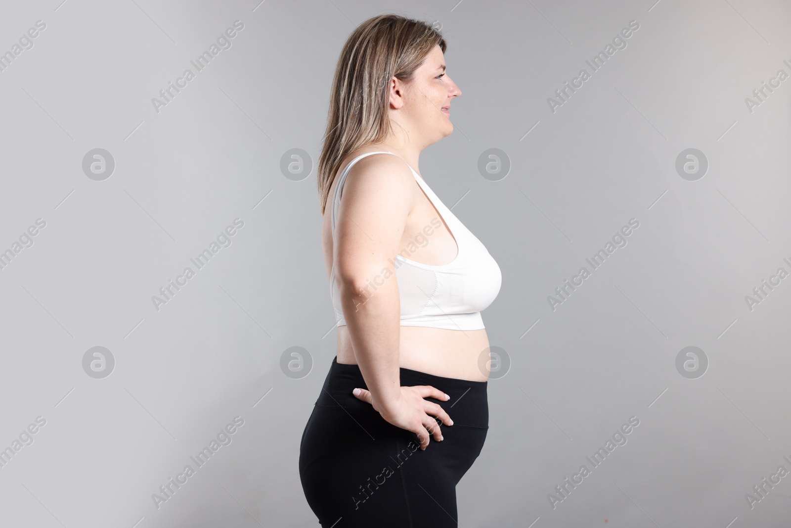 Photo of Weight loss. Plus size woman on gray background