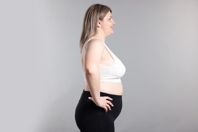 Photo of Weight loss. Plus size woman on gray background