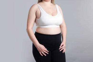 Photo of Weight loss. Plus size woman on gray background, closeup