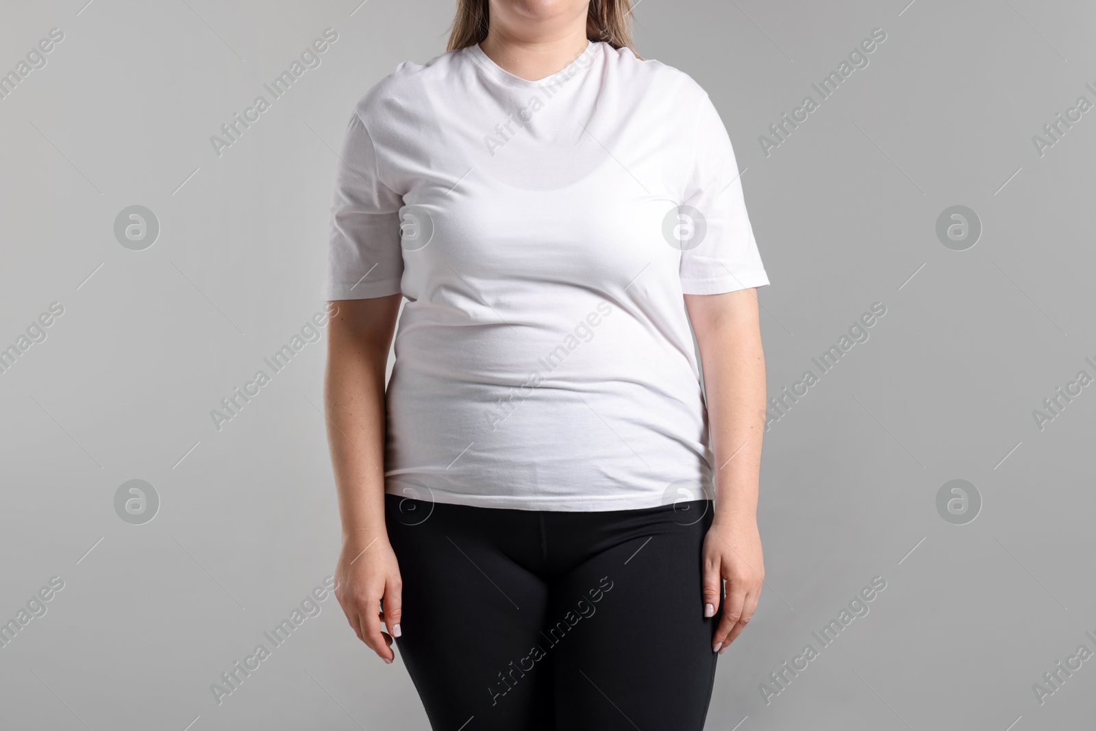 Photo of Weight loss. Plus size woman on gray background, closeup