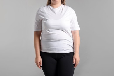 Photo of Weight loss. Plus size woman on gray background, closeup