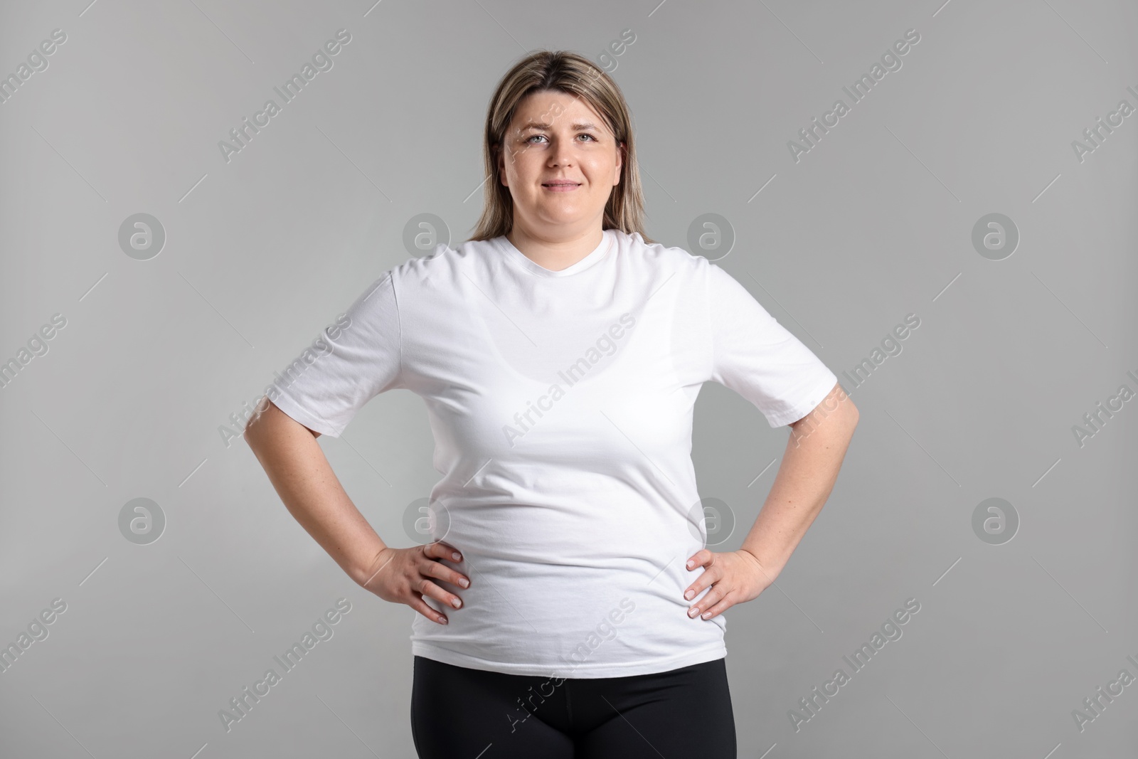 Photo of Weight loss. Plus size woman on gray background