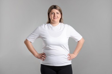 Photo of Weight loss. Plus size woman on gray background