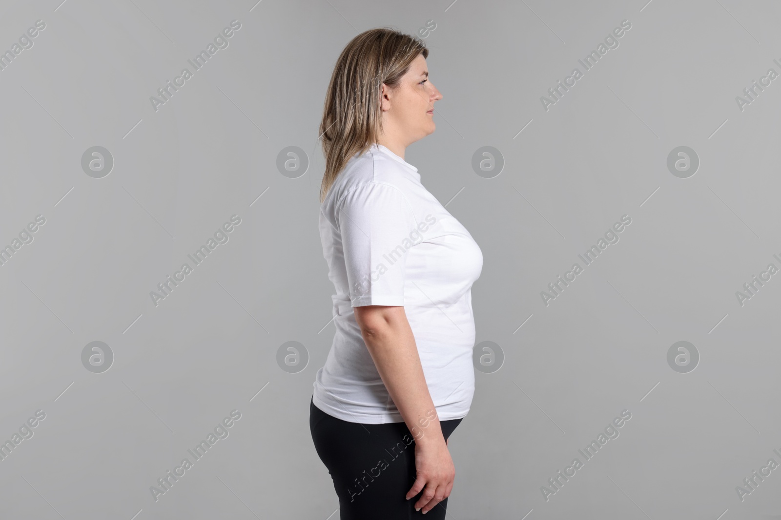 Weight loss. Plus size woman on gray background Photo of Weight loss. Plus size woman on gray background