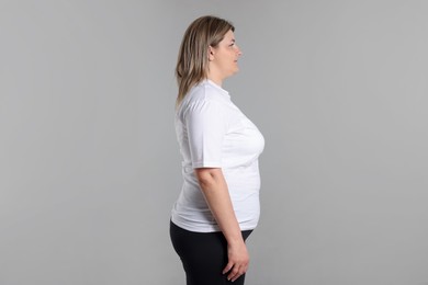 Photo of Weight loss. Plus size woman on gray background