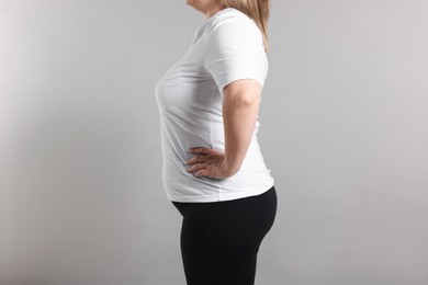 Photo of Weight loss. Plus size woman on gray background, closeup