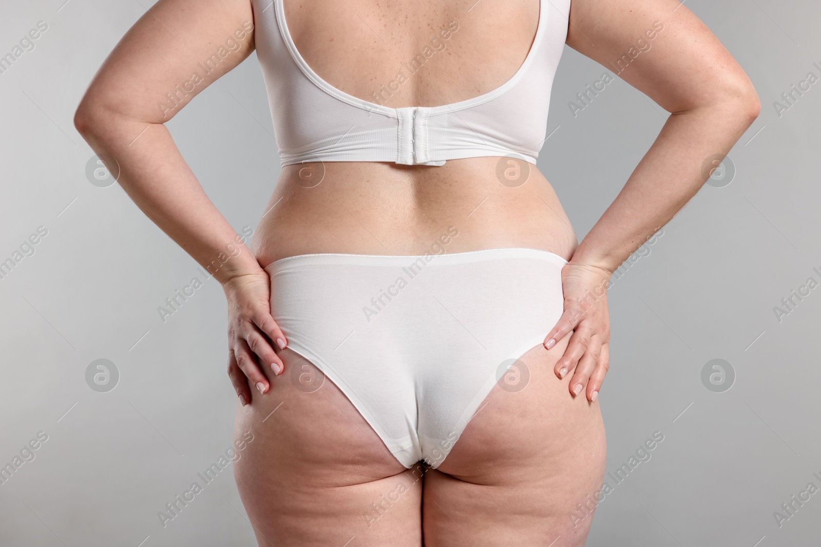 Photo of Weight loss. Plus size woman in underwear on gray background, closeup
