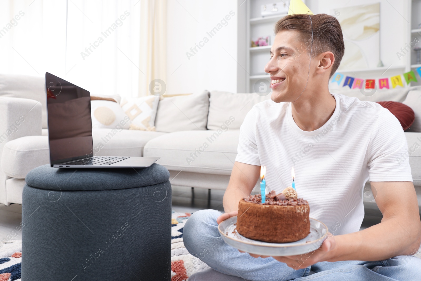 Man with cake celebrating his birthday and having video call via laptop at home Photo of Man with cake celebrating his birthday and having video call via laptop at home