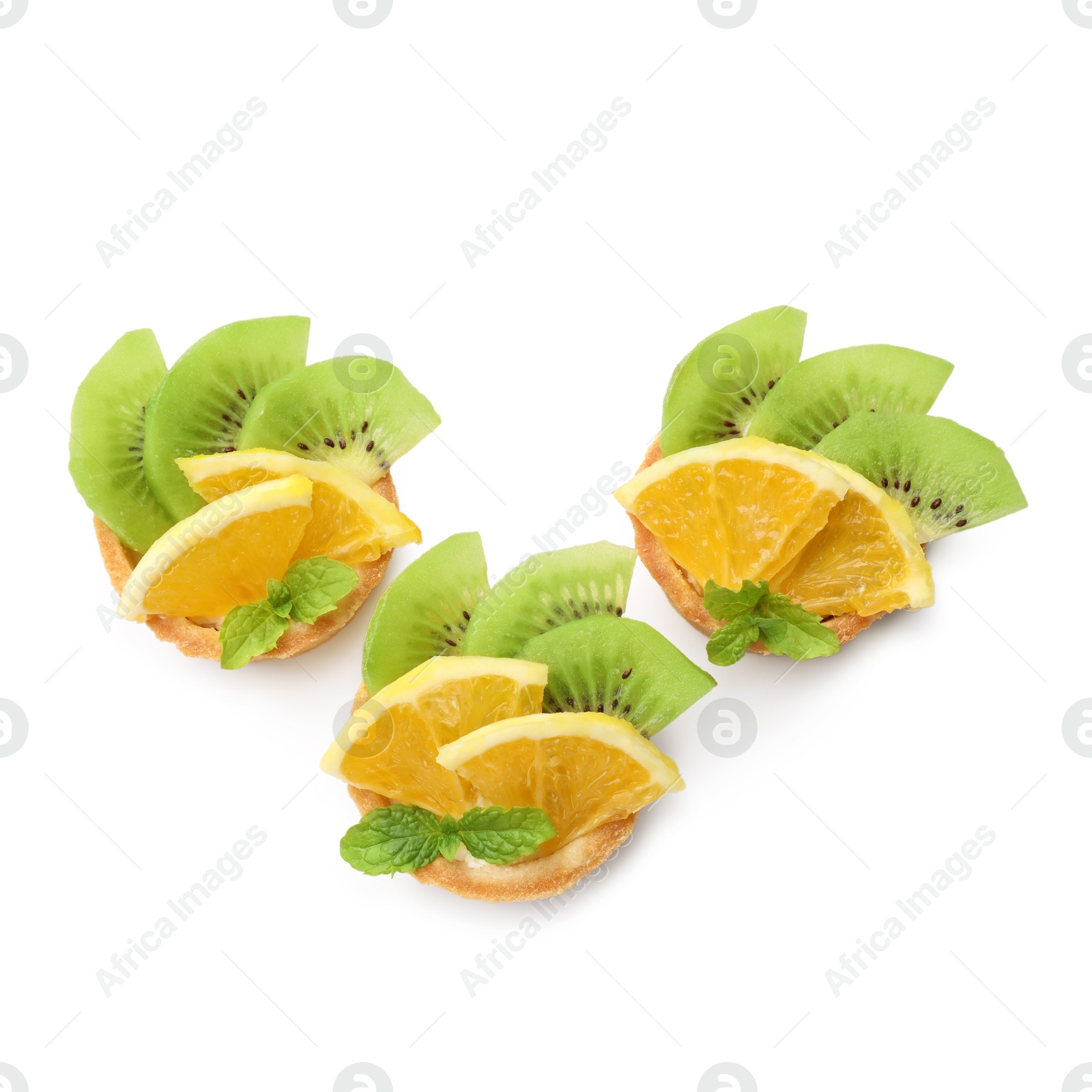 Tartlets with fruits and mint isolated on white, top view. Delicious dessert Photo of Tartlets with fruits and mint isolated on white, top view. Delicious dessert
