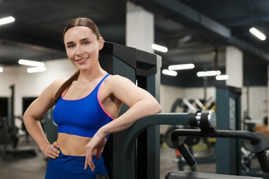 Photo of Portrait of professional personal trainer in gym. Space for text
