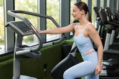 Photo of Personal coach using elliptical trainer in sport center