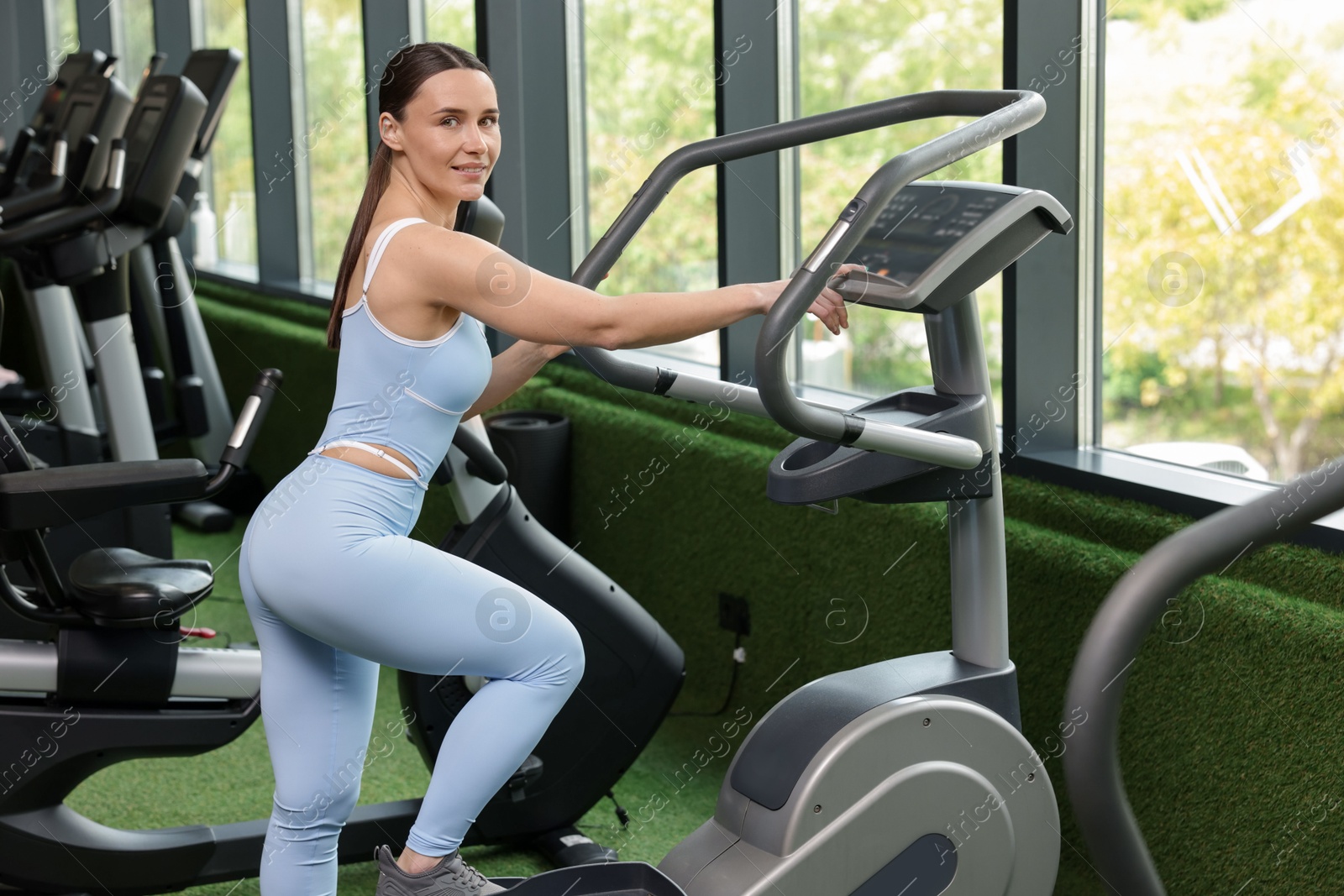 Personal coach using elliptical trainer in sport center Photo of Personal coach using elliptical trainer in sport center